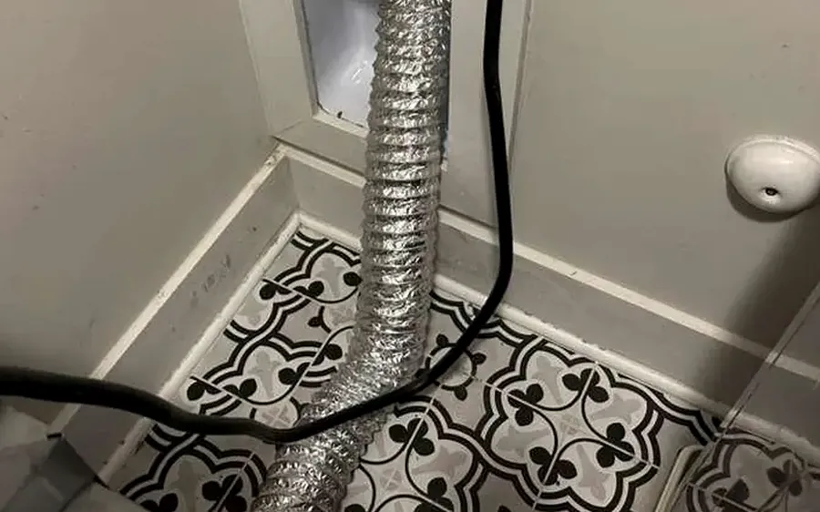 Flexible dryer duct behind a dryer in a laundry room